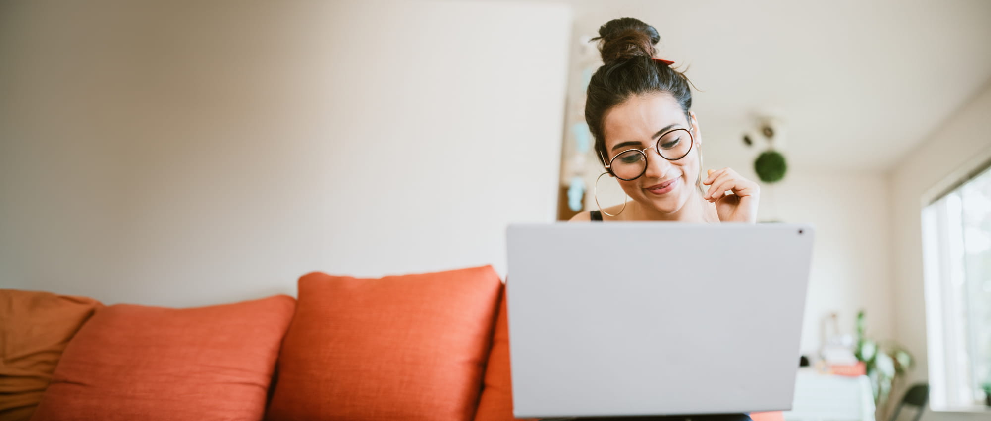 An image of a woman looking at laptop.