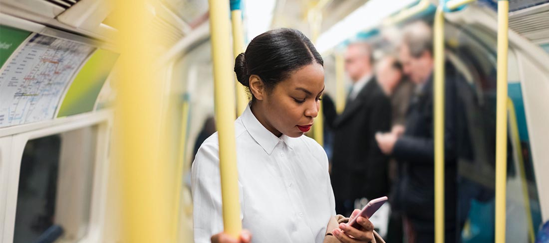 Woman looking at mobile phone on the underground.