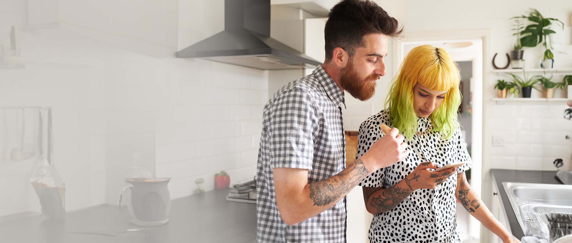 Two people looking at a mobile phone.